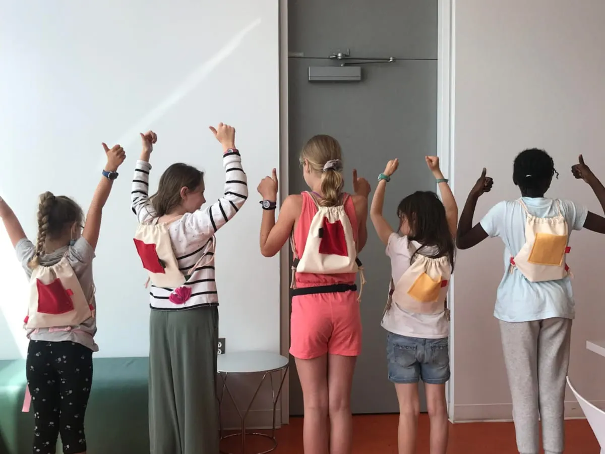 Des enfants de dos avec des sac à dos artisanaux