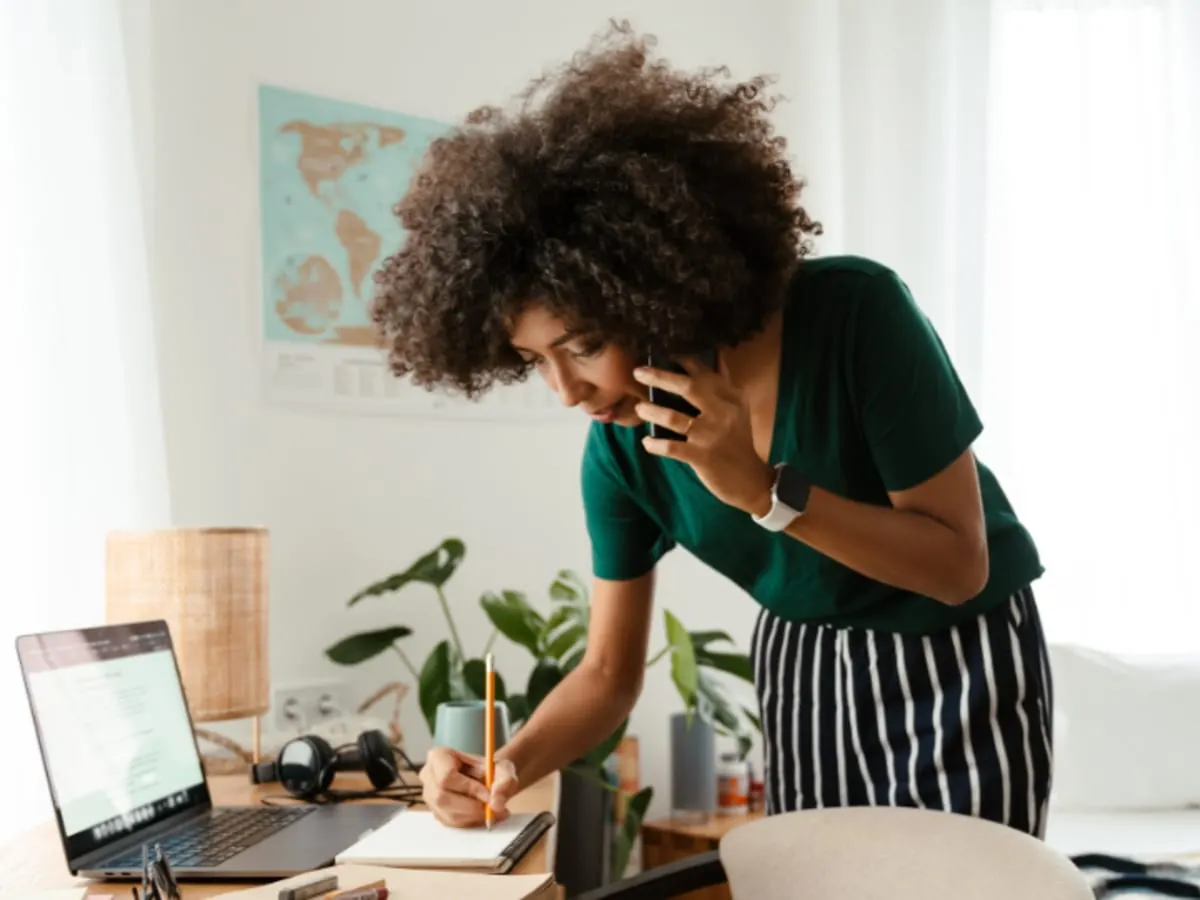 Personne au téléphone qui prend des notes