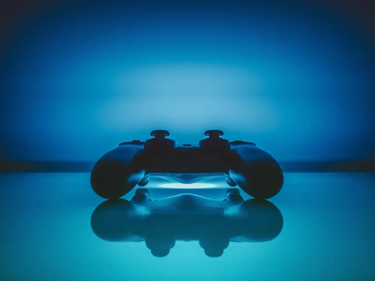 Une manette de jeu vidéo sur fond bleu lumineux.