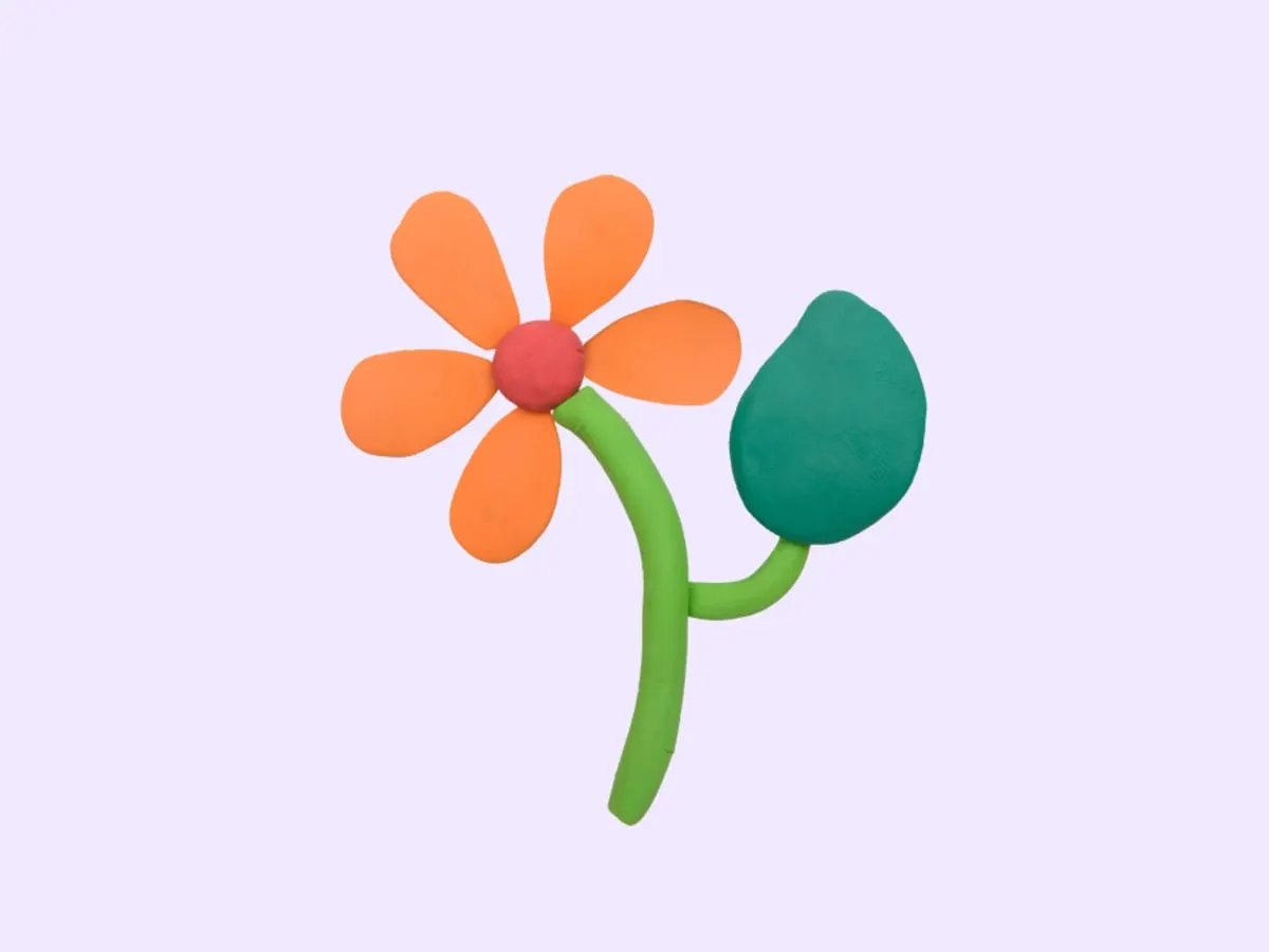 Illustration d’une fleur stylisée en pâte polymère, composée de cinq pétales orange, d’un cœur rouge et d’une tige verte avec une feuille. Le tout est présenté sur un fond mauve pâle uni.