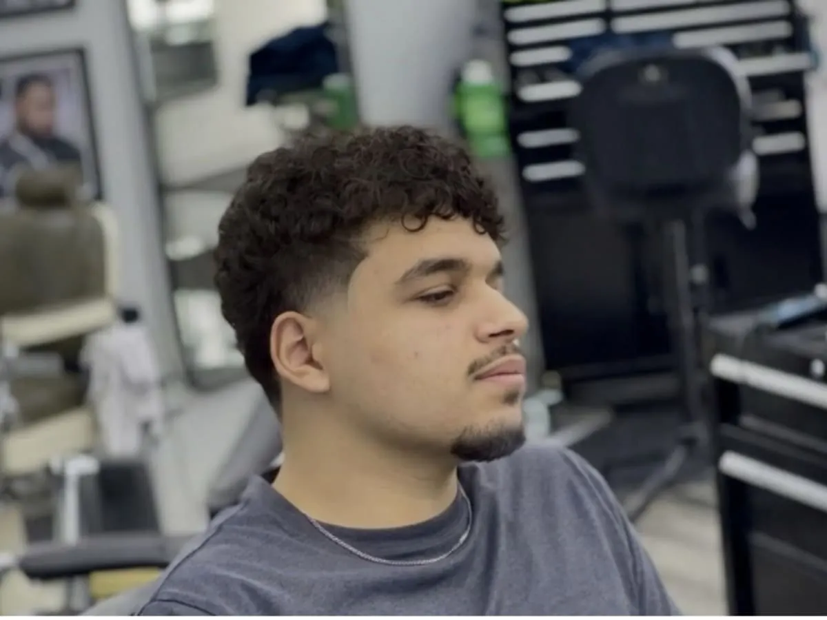 Une photo d'un adolescent avec une nouvelle coupe de cheveux à un barbier