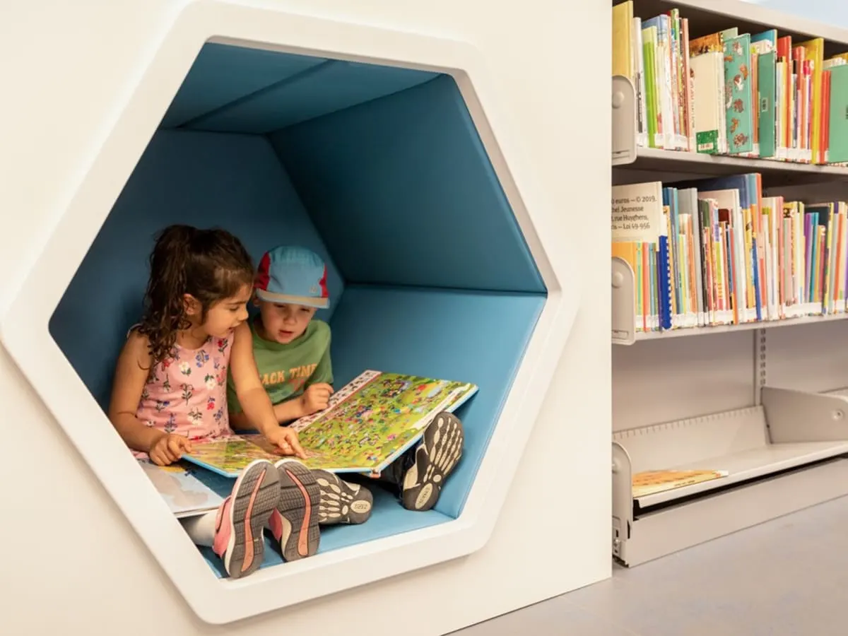 Deux enfants qui lisent à la bibliothèque.