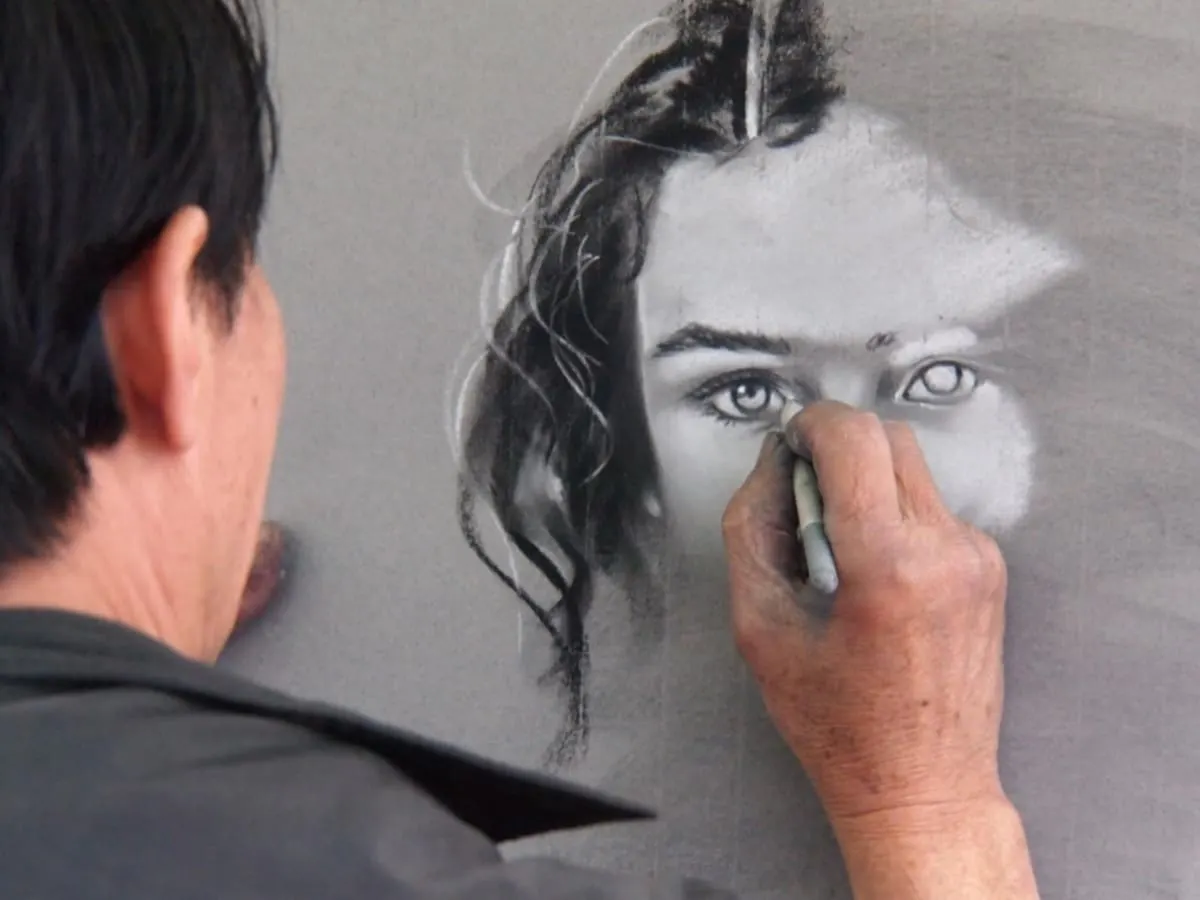 Un homme dessine un visage de femme
