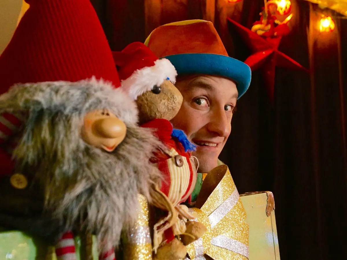 Un homme joyeux derrière des décorations de Noël.