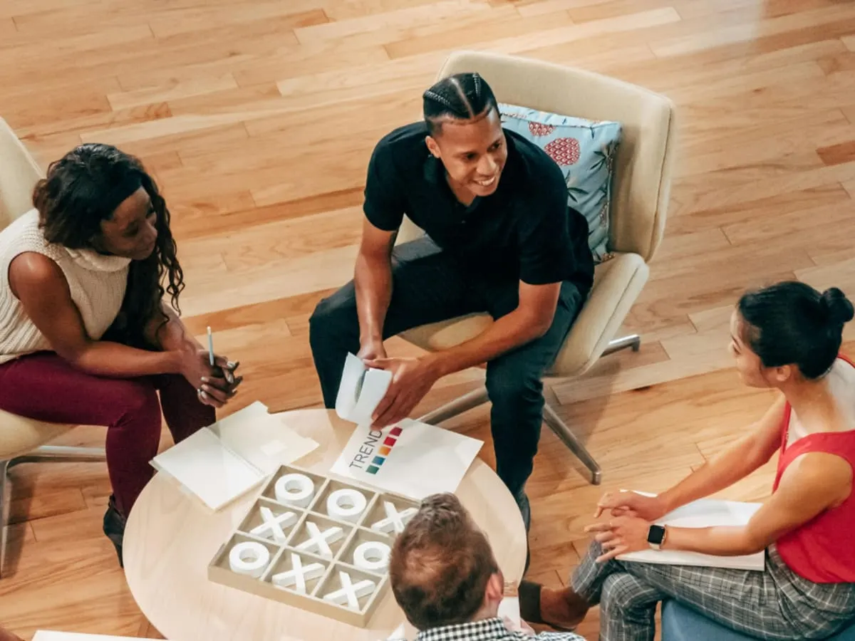 Photo de personnes assises autour d'une table prêtes à jouer à un jeu